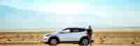Man standing on car in middle of nowhere
