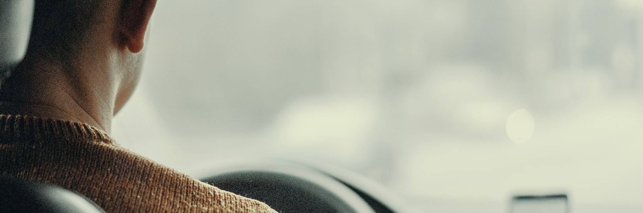 Man Driving Vehicle with Phone in View