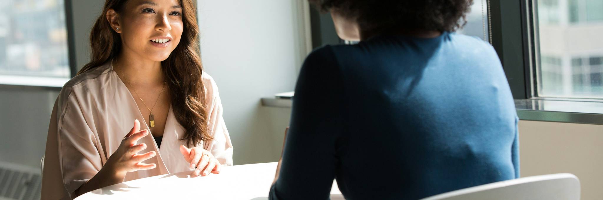 Two women sitting opposite to each other having a discussion